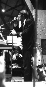 Man in profile speaks into a microphone.