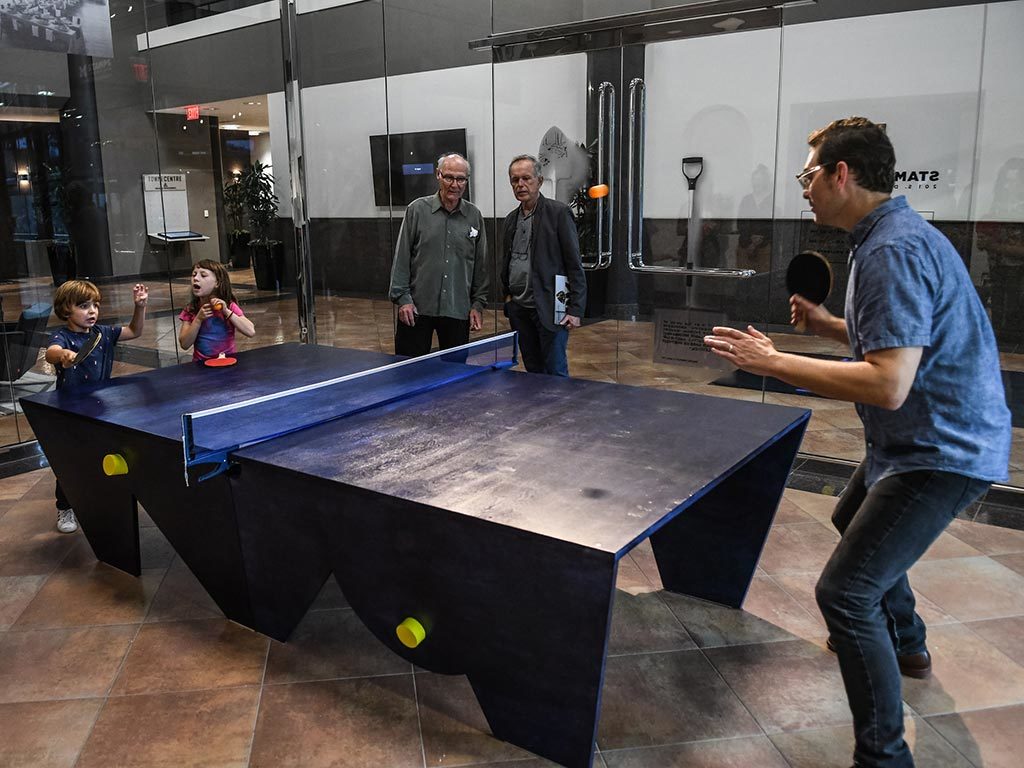 In his new work Prussian Blue (Ping Pong Parlour) Table, 2018, Buster Simpson, MFA '68,  pays homage to the experimental artist collective, the Once Group. The Once Group brought together filmmakers, musicians, visual artists and engineers to present innovative and one-time performances. The Joy Ride Interchange, created by George Manupelli and performed with Joseph Wehrer was one such performance that featured a ping pong table. The experience inspired Simpson to create a custom made ping pong table that transforms the gallery space into a lively meeting place. On Nov. 9, at 4.30 pm, the Stamps Gallery will host a table tennis tournament called the Confabcafe. 