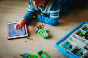 Child plays with legos and iPad