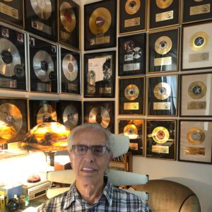 Perry in his office with gold and platinum records.