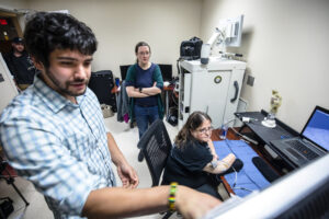 During a critical testing session for the U-M RPNI study, Alex Vaskov, robotics Ph.D. candidate, Cindy Chestek, associate professor of biomedical engineering, and Karen Sussex, study participant, examine parameters for a prosthetic control exercise. Image credit: Evan Dougherty, Michigan Engineering