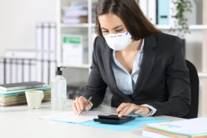 Woman in mask uses calculator