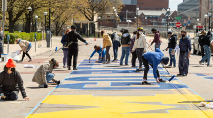 Students paint a mural in front of Rackham to celebrate 2021 graduates. (Image: Eric Bronson)