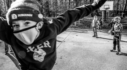 Photo bombing kid in a mask at play.