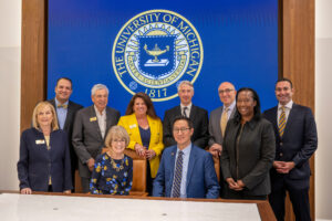 President-elect Santa Ono, seated at right, is shown with President Mary Sue Coleman, seated at left, and, standing from left, Regents Denise Ilitch, Michael Behm, Ron Weiser, Sarah Hubbard, Paul Brown, Mark Bernstein, Katherine White and Jordan Acker. (Roger Hart, Michigan Photography)