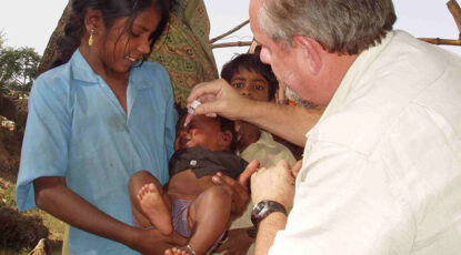 Dr Larry Brilliant gives polio drops to baby