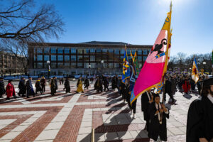 Blue skies and a parade of faculty across the Diag.