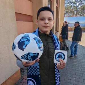 Young boy holds a soccer ball.