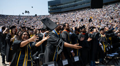 Students toss graduation caps in the air.