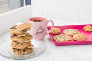 A pink coffee cup and a plate of cookies.