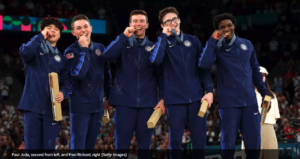 The US Men's Gymnastics team at Paris 2024 Olympics pose with the bronze medals they won on July 29. U-M's Paul Juda is second from left in the group of five athletes dressed in blue athletics wear. Fred Richard is on the far right.