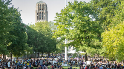 Crowd shot of students on the Diag with Burton Tower in the background.