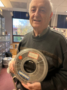 Man holds vintage computer disc.