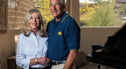 Couple poses in U-M-branded gear together as they donate large gift to U-M cancer research.