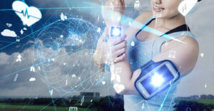 Woman dressed for exercise wears a tracker on wrist and bicep, surrounded by graphics representing healthcare technology.