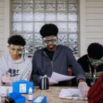 Middle school students wearing science goggles work in a lab as part of the Environmental Health Research-to-Action Academy.