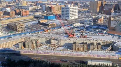 Overhead shot of UMCI construction site in Detroit, with snow, and large orange crane. Land was purchased from MGM Grand Detroit.