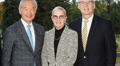 Three well-dressed people stand in a line. From left, the late Tachi Yamada and his wife, Leslie, and Joseph C. Kolars. (Photo courtesy of the Center for Global Health Equity)