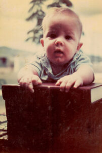 Snapshot, circa 1967, of baby propped up on textbooks.