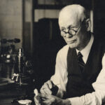 A caucasian man in sepia tones sits in a medical laboratory at the University of Michigan