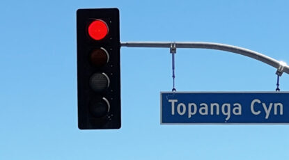 Topanga Canyon road sign with red light.