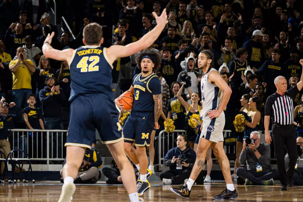 Michigan basketball player No. 3, Tre Donaldson, reacts to No. 42, Will Tschetter, in a game agains Penn State.