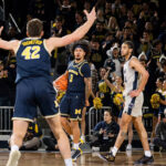 Michigan basketball player No. 3, Tre Donaldson, reacts to No. 42, Will Tschetter, in a game agains Penn State.