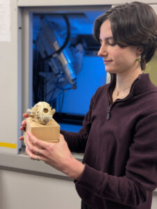 Woman holds small skull in laboratory.