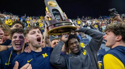 Group of University of Michigan gymnasts, including Olympian Fred Richard, hoist up the NCAA championship trophy on April 19, 2025, at Crisler Arena.