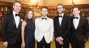A family wtih two parents and three young adult sons dressed in formal wear.