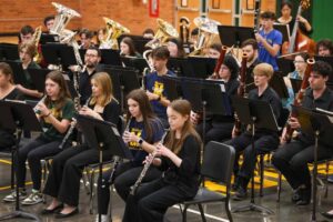 U-M students, in black concert attire, are interspersed with high school students from two Midland high schools.
