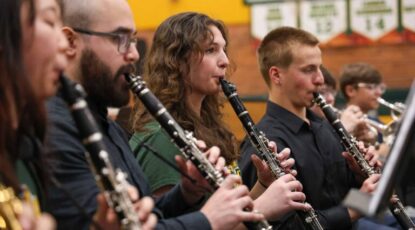 Members of the U-M Symphony Band perform with high school students in Michigan.