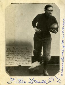 Vintage photograph, circa 1920, of Dr. Tom Lovell of Ann Arbor, dressed in football gear of the time, with ball tucked into his left arm.