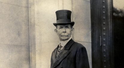 Image of caucasian man with a mustche, circa 1920, dressed in formal wear with top hat and tie.