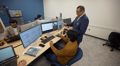 At UM-Flint Khalid Malik advises students in a computer lab, using AI to tackle tomorrow’s toughest problems.