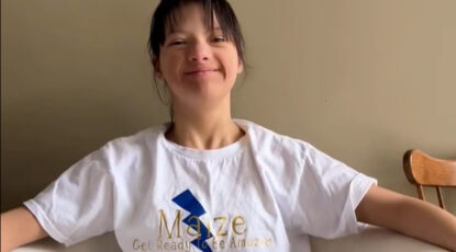 Ann Arbor, Mich-based teenage girl with big smile wears a t-shirt with a blue lightning bolt that reads Maize: Get ready to be amaized -- in support of the U-M Women's Basketball team at the University of Michigan.
