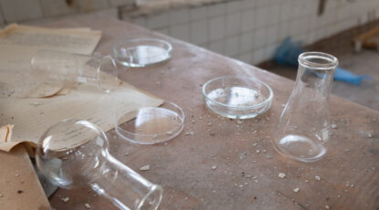 An abandoned lab table shows overturned beakers and petri dishes. Stock image