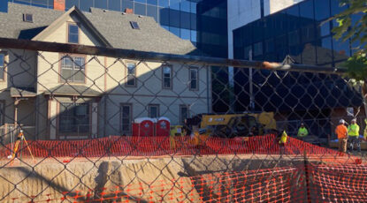 Construction site shows chain link fence, Arthur Miller house on Division street and the Institute for Social Research building at University of Michigan.