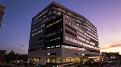 Modern hospital building lit up at night.