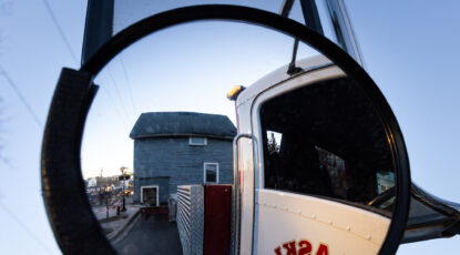 An image of World War II hero Raoul Wallenberg's student dwellling on wheels as seen through the rear-view mirror of the truck driving it on the campus of the University of Michigan.