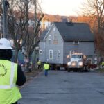 Truck begins driving on Madison Street with Raoul Wallenberg house on flatbed.