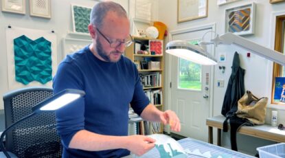 Artist working in a studio to create paper art that appears in the D. Dan and Betty Kahn Pavilion at Michigan Medicine at U-M in Ann Arbor.