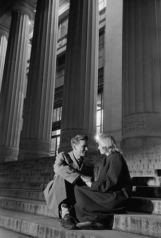 Black and white image of a University of Michigan student couple, male and female, seated on the steps of Angell Hall in the evening. 1949. (Image credit: Stanley Kubrick, Look magazine photograph collection, Library of Congress.)