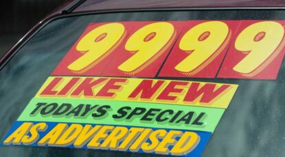 Sign on car windshield advertises "Like New!"