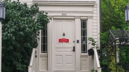 Front door of a white colonial house. It is the entrance to the Museum on Main in Ann Arbor, Michigan.