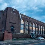 Image shows damage to Yost Ice Arena after two tornadoes touched down in Ann Arbor April 14, 2026. The first touched down at 1:44 a.m. near the Interstate 94 eastbound entrance ramp at Jackson Avenue. The second touched down two minutes later at the intersection of West William Street and Fourth Street near the Argus Building. The tornadoes were both EF1, which corresponds with winds of 86-110 mph. Pieces of the metal roof litter the sidewalk along State Streeet. (Image credit: Michigan Commons.)