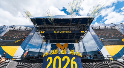 Stage at 2026 Commencement is festooned with University of Michigan iconography.