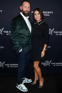 Couple dressed for a nice party stands in front of step-and-repeat banner that reads The Humane Society of the United States.