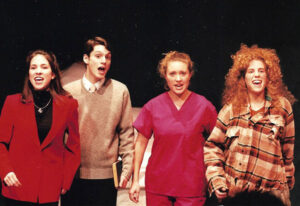 Four actors sing on stage.