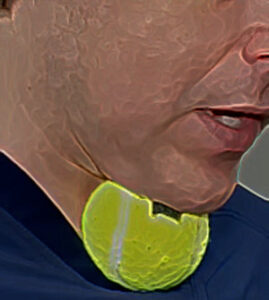 Caucasian person holds tennis ball under the chin.